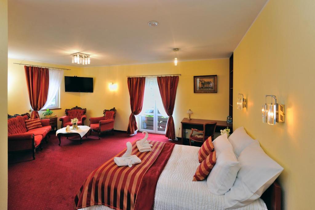 Hotel Na Błoniach في بييلسكو بياوا: غرفة فندق فيها سرير عليه حشرتين محشوتين
