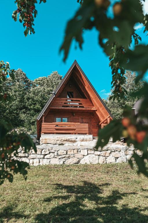 a cabin on a hill with a stone wall at Domaćinstvo braća Rebić in Gacko