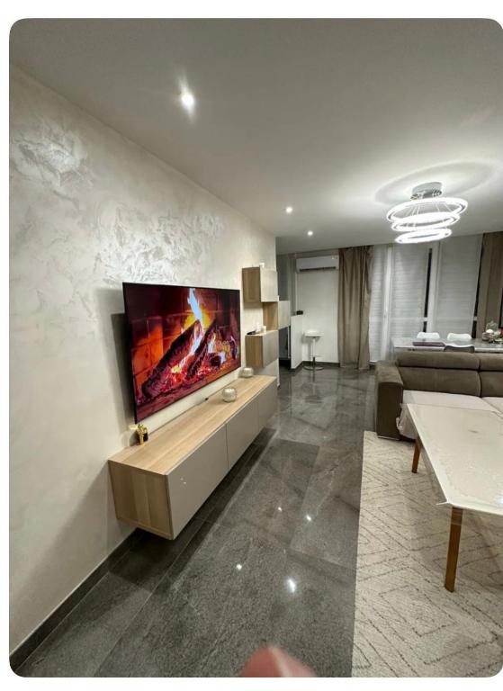 un salon avec une télévision à écran plat sur un mur dans l'établissement Grand paris JO24 Expo Park ,CDG , Bourget, Disney,Astérix, à Villepinte