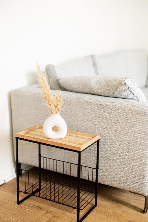 un vase sur une table à côté d'un canapé dans l'établissement HELIANTHE - Cosy et spacieux refait à neuf tout confort, à Saint-Étienne