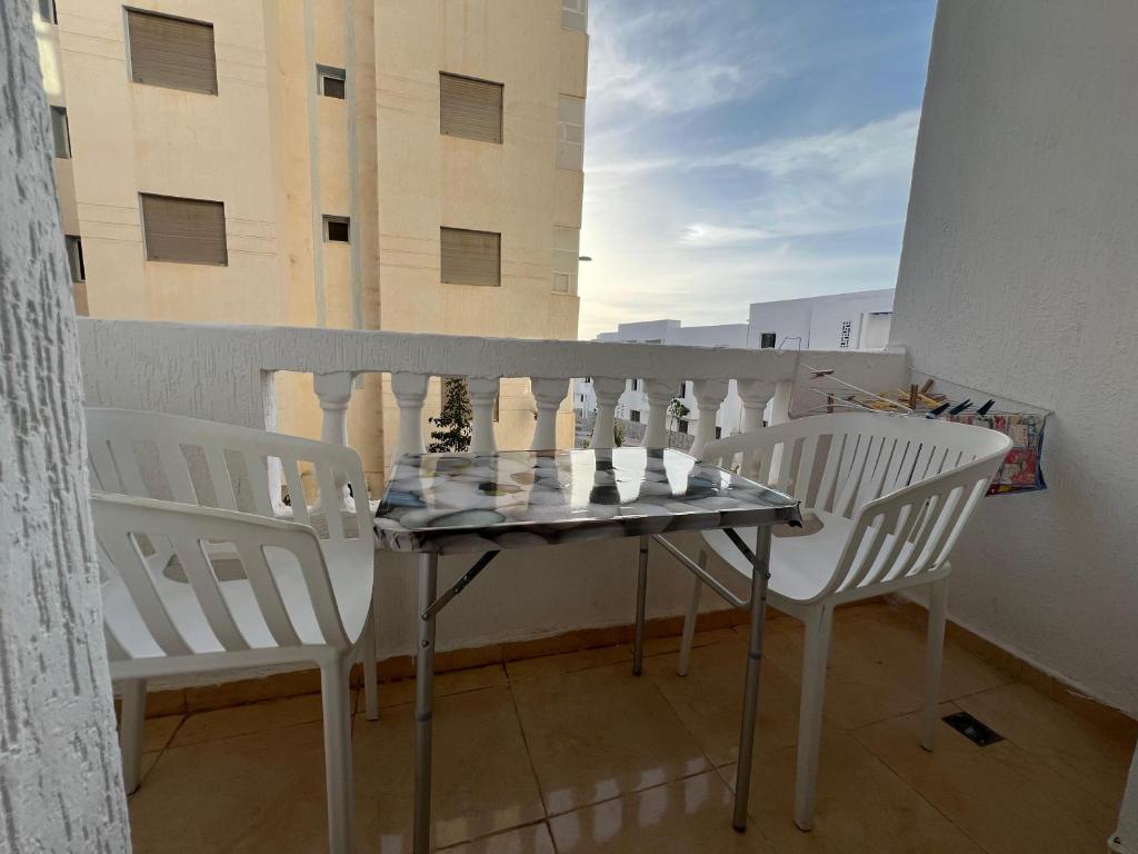 a table and chairs on a balcony with a view at Appartement des vacances à Bades près de corniche in Al Hoceïma