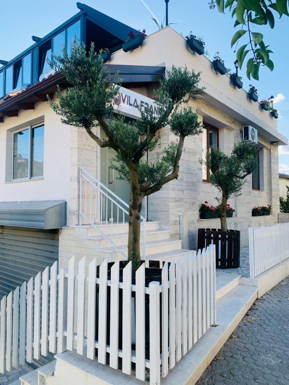 a white fence in front of a house at Vila Franko in Berat