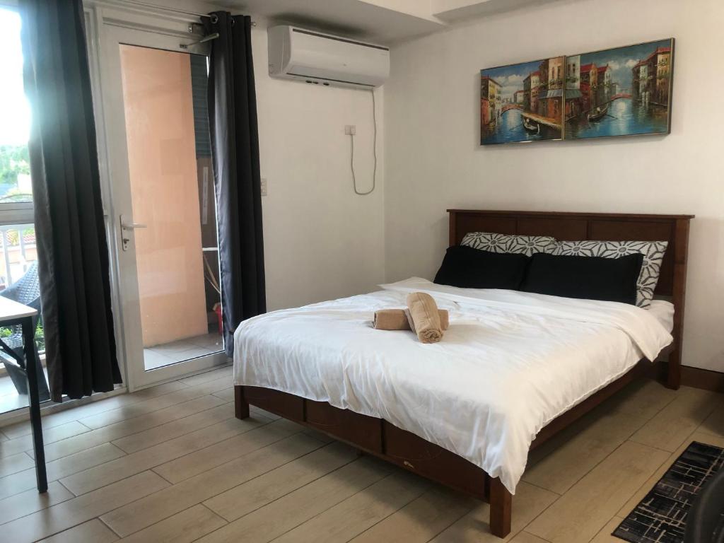 Un dormitorio con una cama con un osito de peluche encima. en Victorian Place Simple yet Luxurious, en Manila