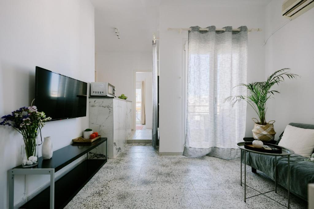 a living room with a couch and a tv at Stadium Apt in Kos