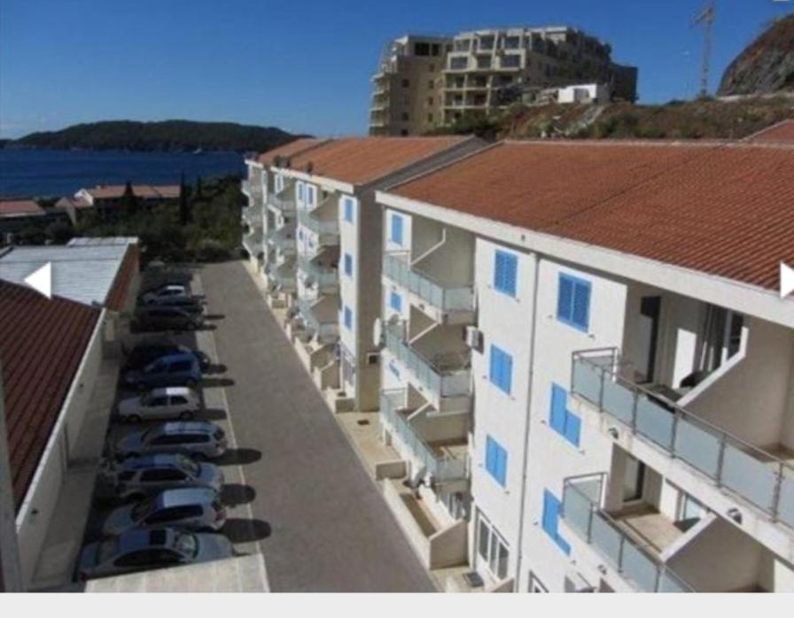 arial view of a building with cars parked in a parking lot at Apartman Cristo Becici in Rafailovici