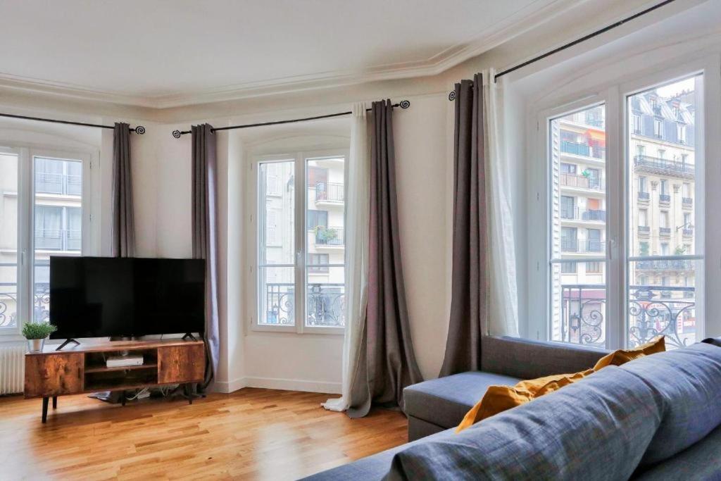 un salon avec un canapé et une télévision à écran plat dans l'établissement Appartement QUARTIER EMILY IN PARIS NOTRE DAME, à Paris