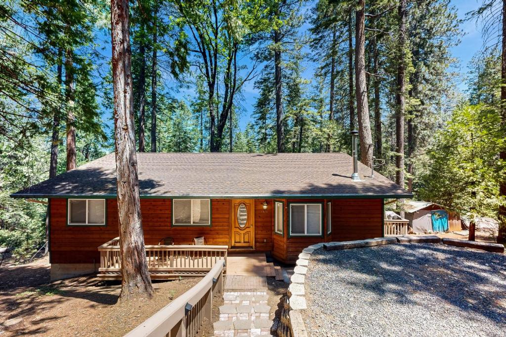a wooden house with a porch and a tree at Fire Pit, Near Lake: 'Evergreen Escape' in Arnold in Arnold