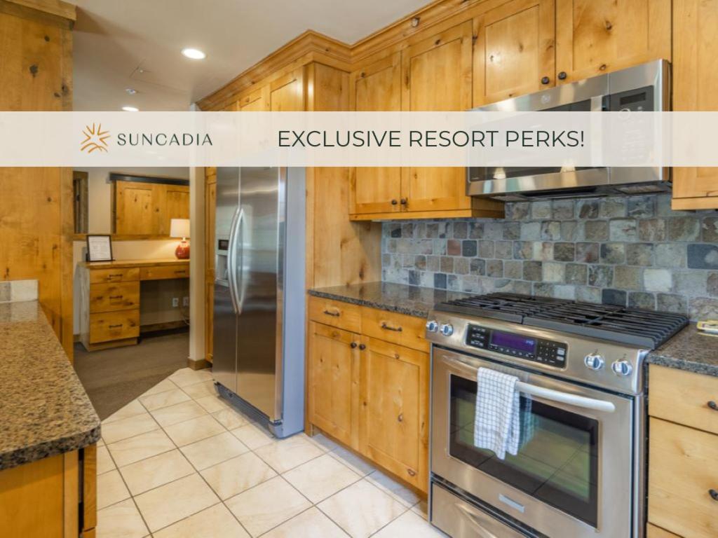 a kitchen with wooden cabinets and a stove top oven at Suncadia Trailhead 1 Pet Friendly Condo 205 in Cle Elum