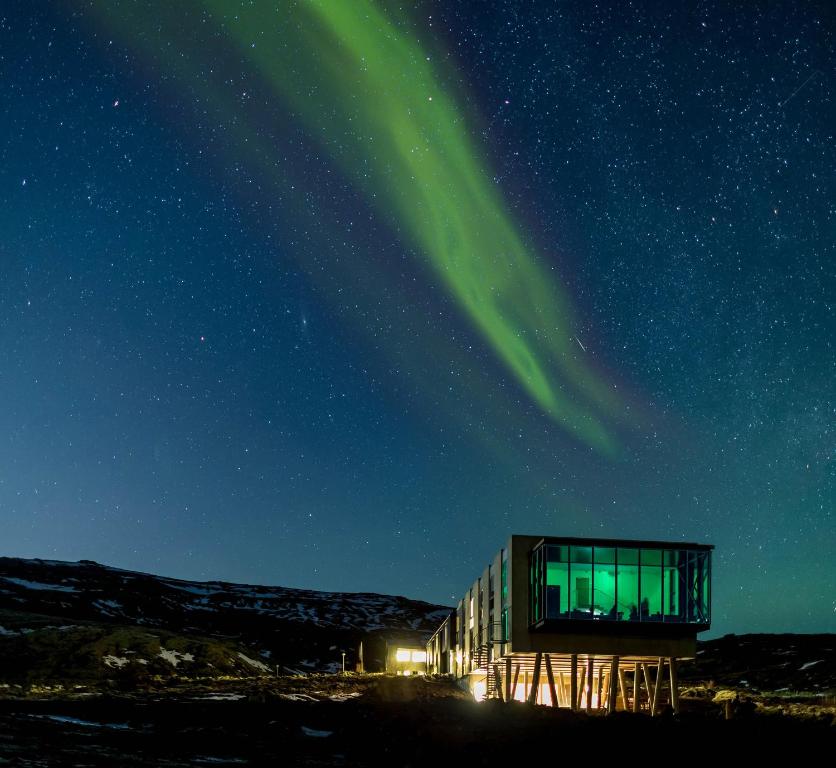 an observatory with the green northern lights in the sky at ION Adventure Hotel, Nesjavellir, a Member of Design Hotels in Nesjavellir