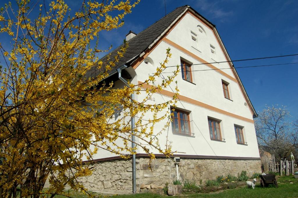 a large white building with a clock on it at Kozí Farma U Nýdrlů in Stará Červená Voda