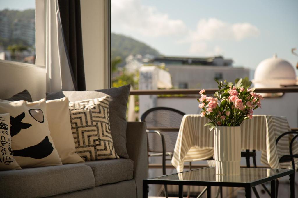 a living room with a couch and a table with flowers at Makari Vallarta in Puerto Vallarta