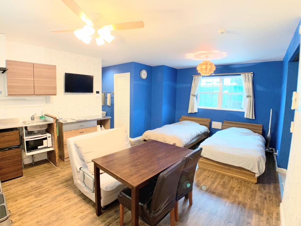 a room with two beds and a table and a kitchen at Alaula - Vacation STAY 22838v in Izumi-Sano