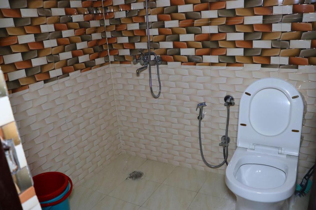 a bathroom with a toilet and a shower stall at Sattva Retreat One Bedroom Chalets in Almora