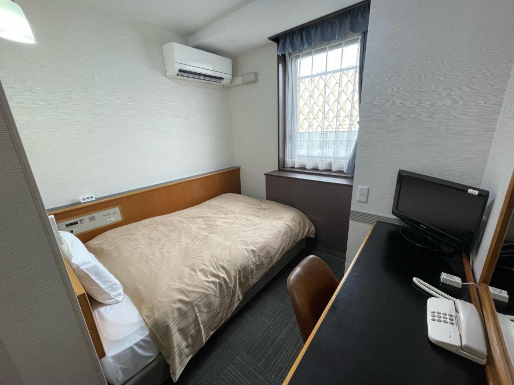 Postel nebo postele na pokoji v ubytování Terminal Hotel Matsuyama