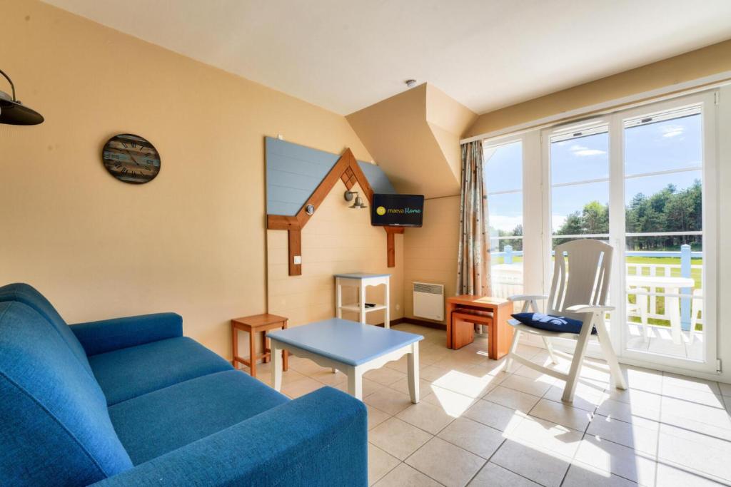 ein Wohnzimmer mit einem blauen Sofa und einem Tisch in der Unterkunft Résidence Belle Dune - maeva Home - Appartement 2 pièces 4 personnes - Sélection MAE-3751 in Fort-Mahon-Plage
