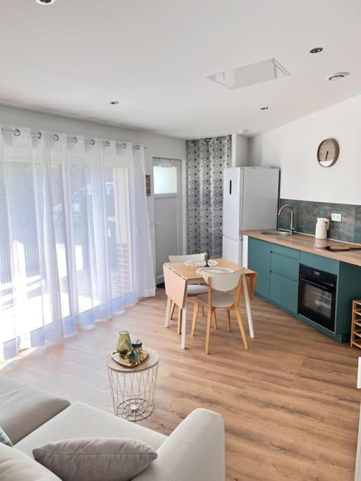 une cuisine et un salon avec une table et des chaises dans l'établissement La belle Iris, à Longueau