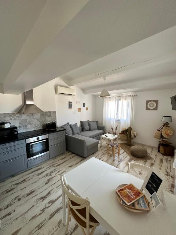 a living room with a couch and a table at Appartement cosy Le Bohème, à 300m des plages LOCAMARGUE in Saintes-Maries-de-la-Mer