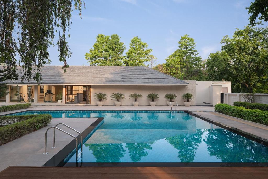 密拉特Modi Estate, Meerut - AM Hotel Kollection的房子后院的游泳池