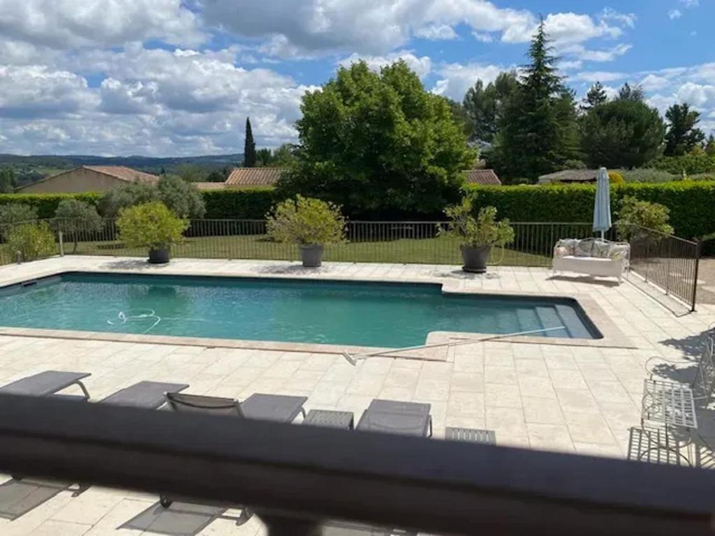 a swimming pool with chairs in a yard at Villa spacieuse proche de Marseille avec jardin et piscine privée in La Tour-dʼAigues