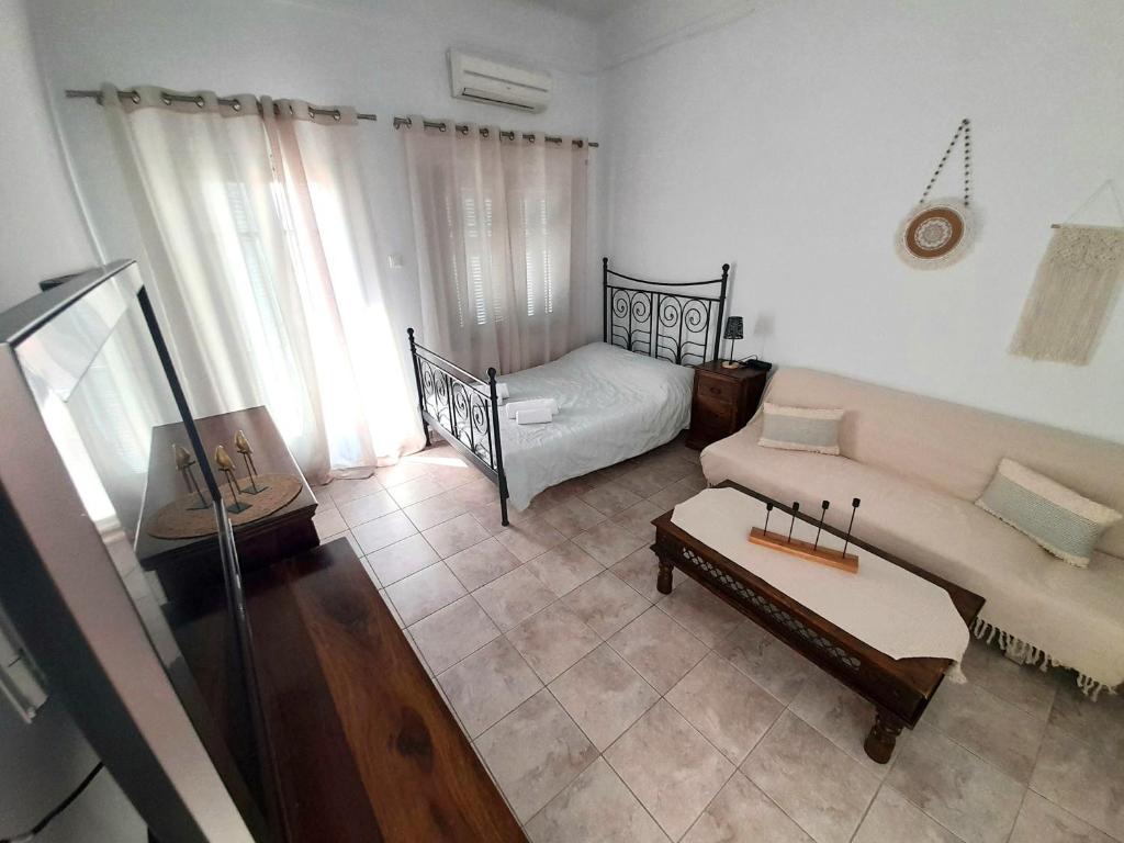 un salon avec un canapé et un lit dans l'établissement Louisa's Home, à Ermoúpoli