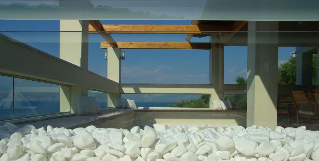 a house with a swimming pool with white rocks at Vista Petros in Apraos