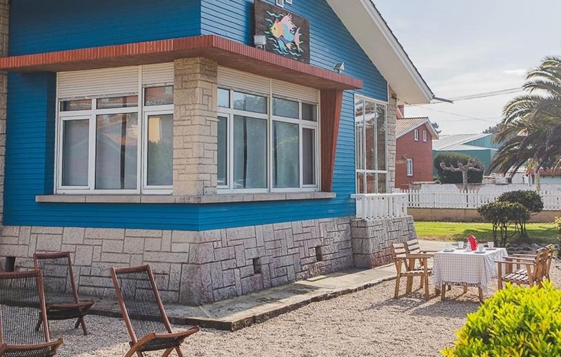 a blue house with a table and chairs in front of it at El Pez Escorpion in Salinas