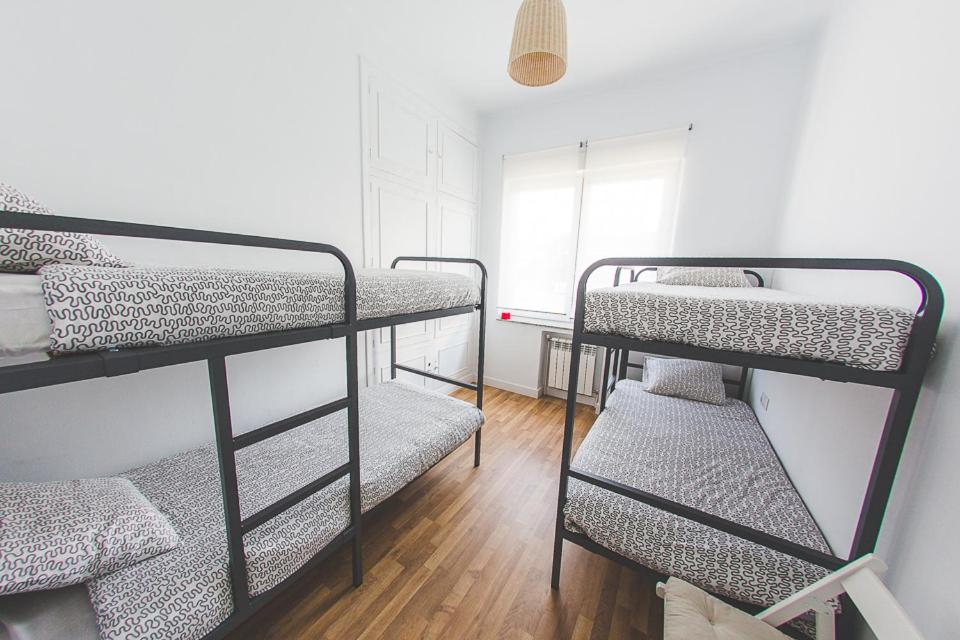 a room with three bunk beds and a window at El Pez Escorpion in Salinas