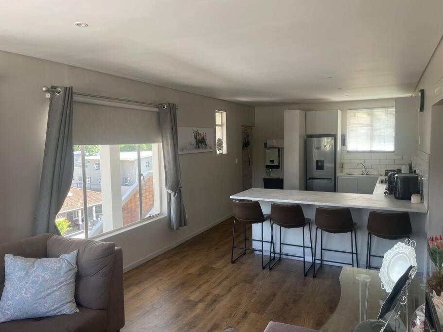 een keuken met een bar met krukken in een kamer bij Royal Mountain Apartment in Paarl