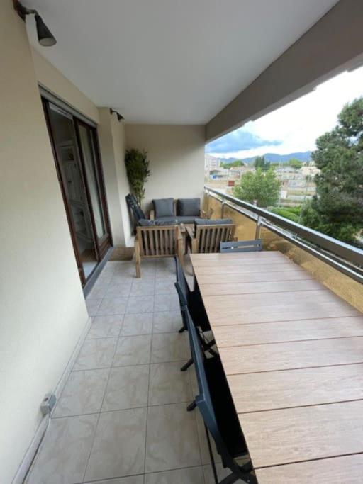 un balcon avec une table et des chaises sur un immeuble dans l'établissement Appartement T3 rénové à 5 min de la plage - Fréjus, à Fréjus