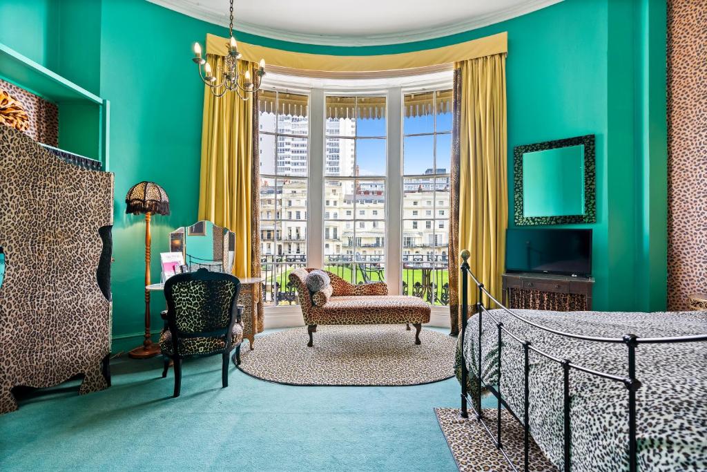 a bedroom with green walls and a bed and a chair at Hotel Pelirocco in Brighton & Hove