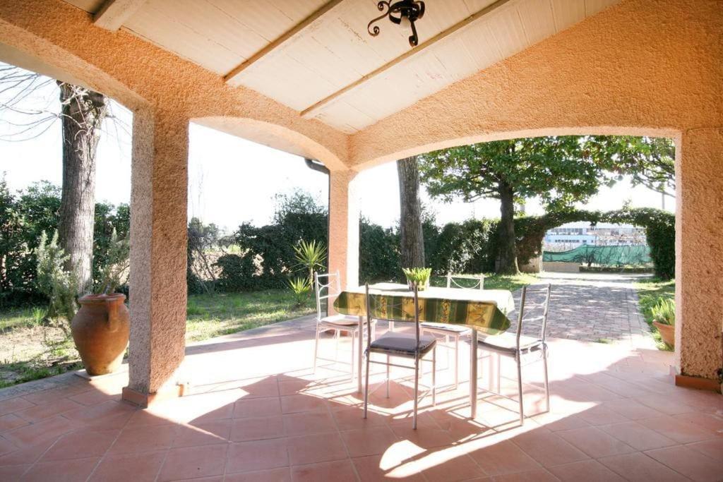 Un patio con una mesa y sillas. en Villetta bifamiliare nel verde a Pietrasanta, en Pietrasanta