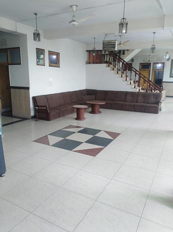 a lobby with a couch and two tables and stairs at Hotel AL-Habib Islamabad in Islamabad