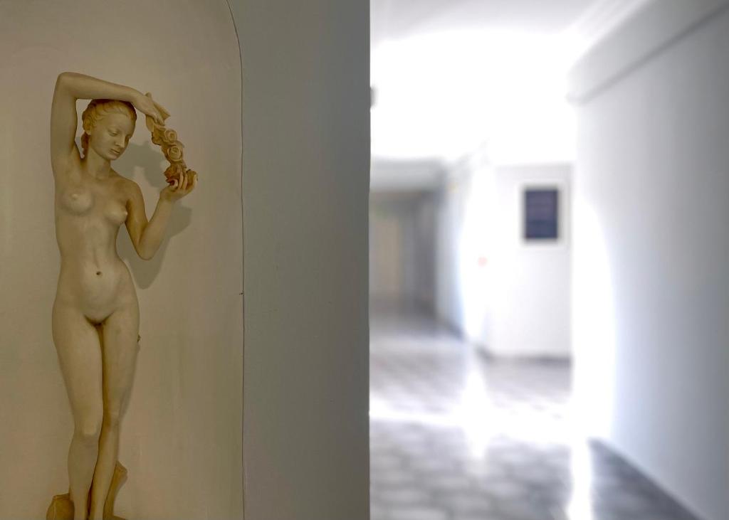 a statue of a man leaning on a wall at Albatros Hotel in Karterados