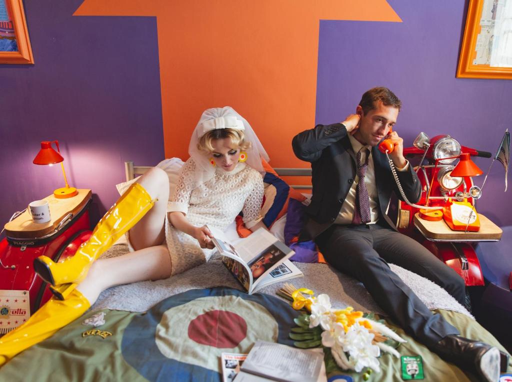 a bride and groom reading a book in their room at Hotel Pelirocco in Brighton & Hove