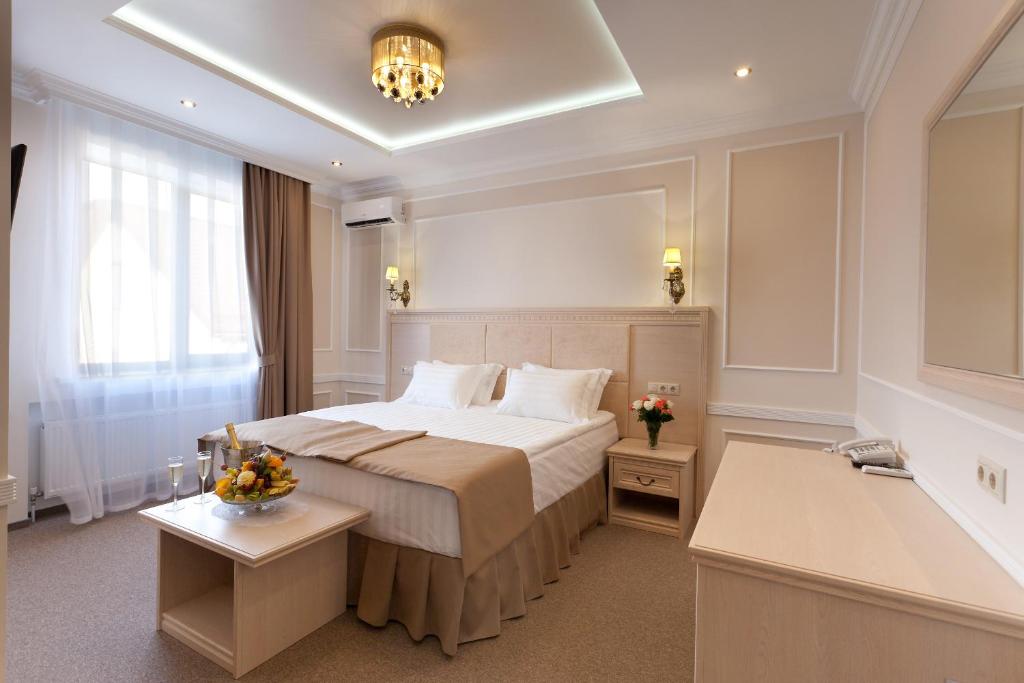 a hotel room with a large bed and a bathroom at Chocolatier Hotel in Krasnodar