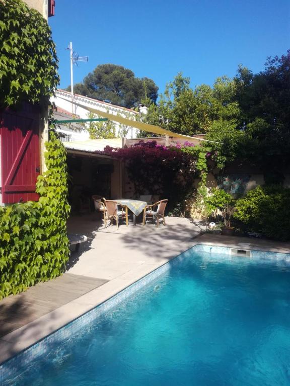 - une piscine avec une table et des chaises à côté d'une maison dans l'établissement Domica, à Grasse