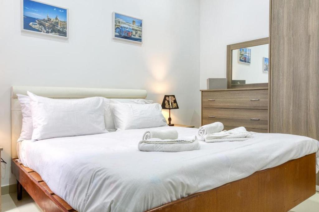 a bedroom with a large bed with towels on it at NR Retreat in Il-Gżira