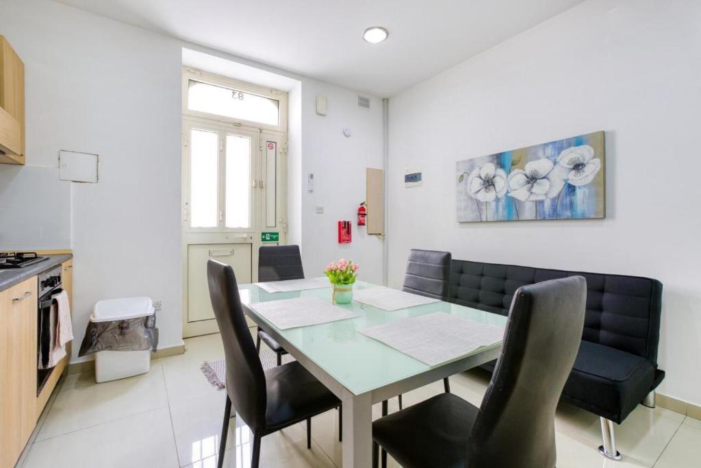 a kitchen and dining room with a table and chairs at NR Retreat in Il-Gżira