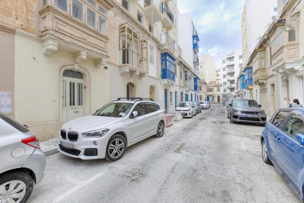 a white car parked on the side of a street at NR Retreat in Il-Gżira
