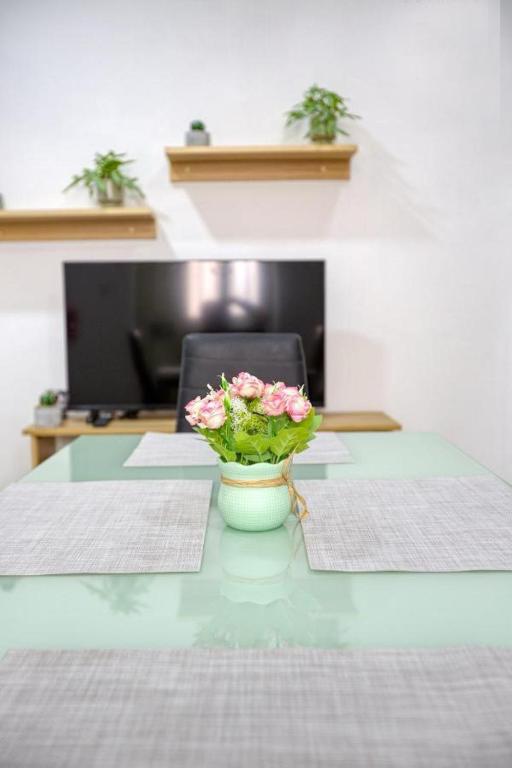 a table with a vase with flowers on it at NR Retreat in Il-Gżira
