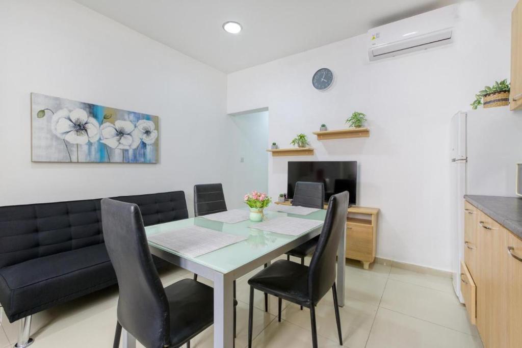 a kitchen and dining room with a table and chairs at NR Retreat in Il-Gżira