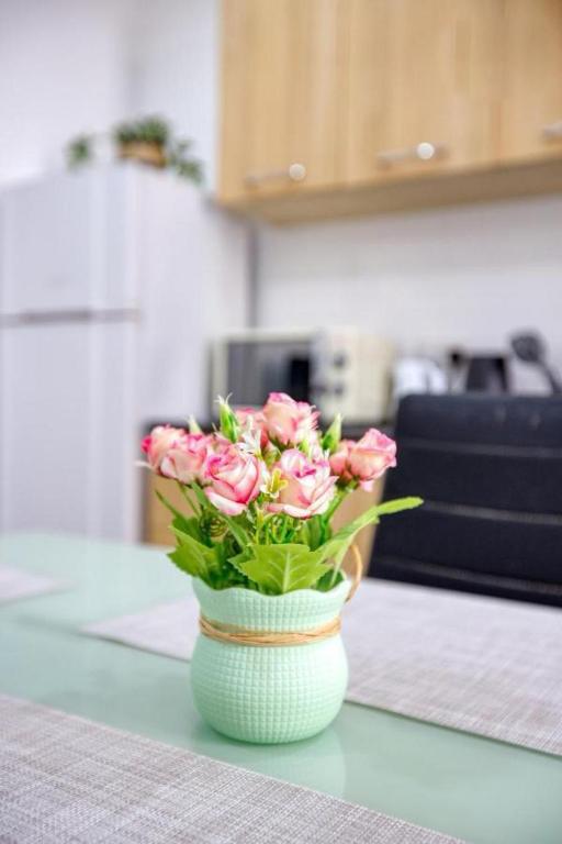 a vase filled with pink flowers sitting on a counter at NR Retreat in Il-Gżira