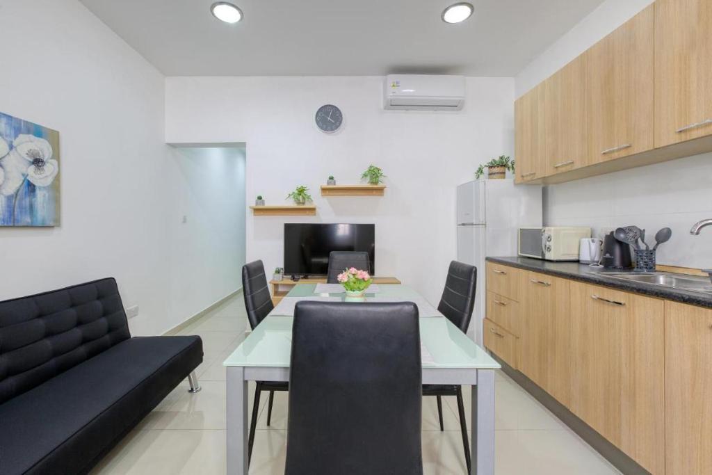 a kitchen and dining room with a table and chairs at NR Retreat in Il-Gżira