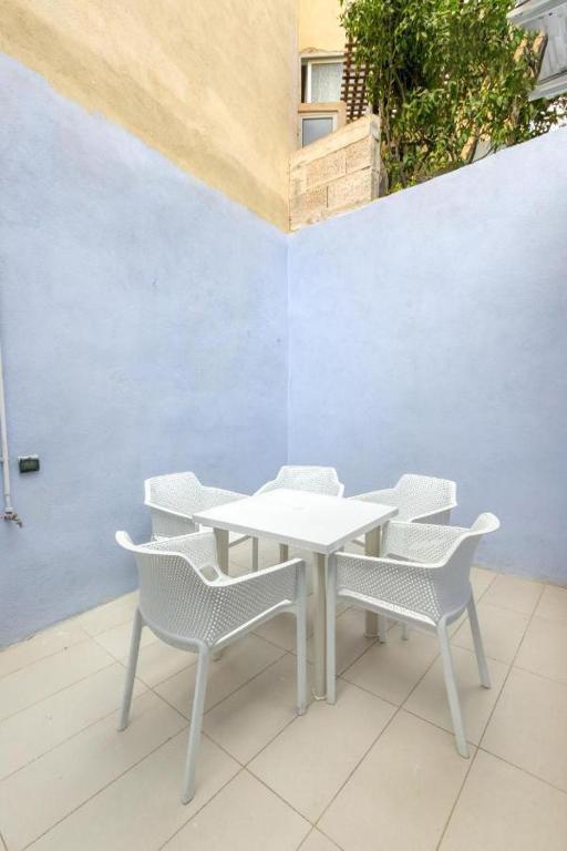 a white table and chairs on a patio at NR Retreat in Il-Gżira