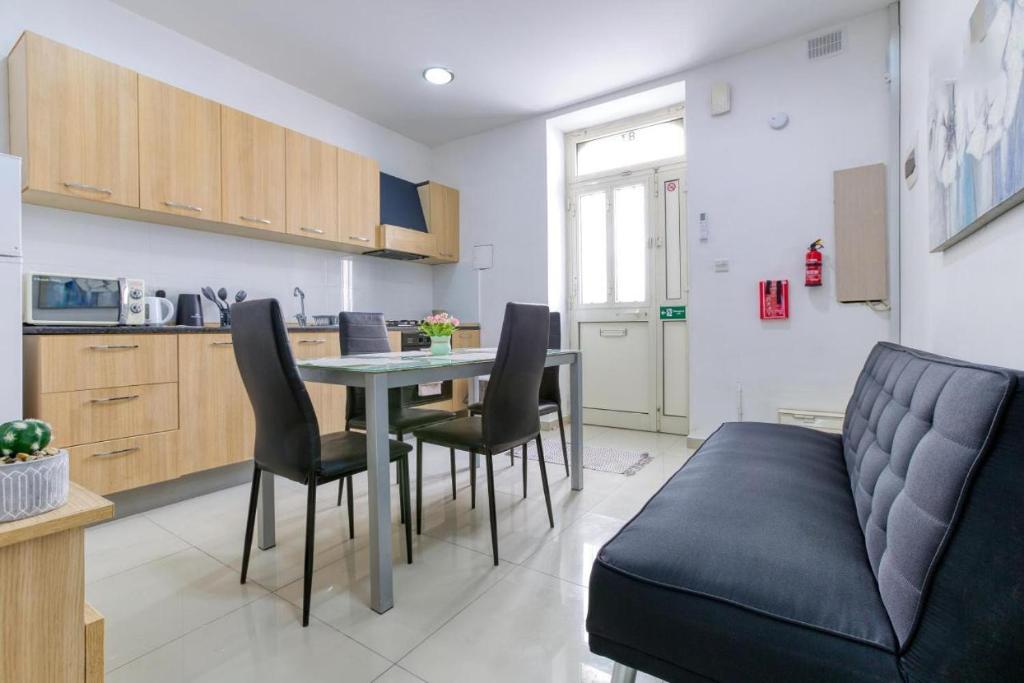 a kitchen and dining room with a table and chairs at NR Retreat in Il-Gżira