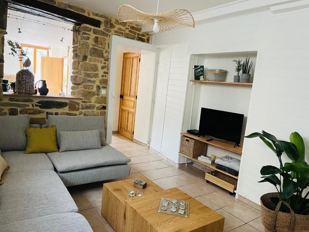 ein Wohnzimmer mit Sofa und Tisch in der Unterkunft La Maison Cosy in Frontenay