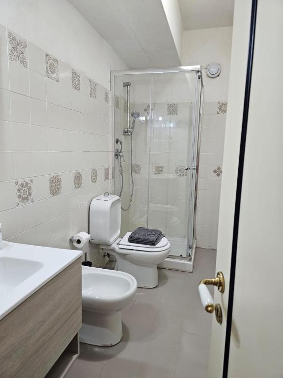 a bathroom with a shower and a toilet and a sink at Hotel Fernanda in Letojanni