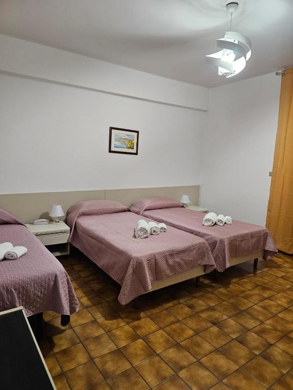 a bedroom with two beds with towels on them at Hotel Fernanda in Letojanni
