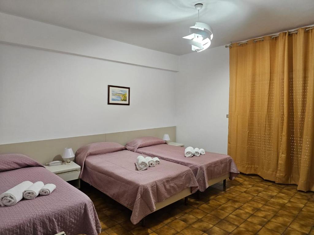 a bedroom with two beds with hello kitty towels on them at Hotel Fernanda in Letojanni