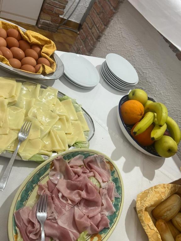 a table topped with plates of food and bowls of fruit at Hotel Fernanda in Letojanni